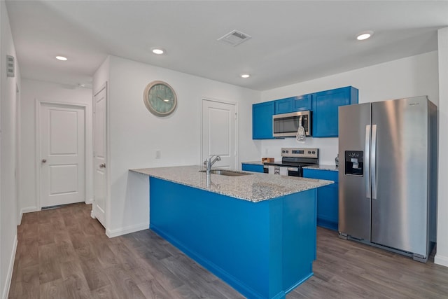 11947 Midas Ln, Willis, TX 77378 - kitchen with appliances with stainless steel finishes, a sink, blue cabinetry, dark wood finished floors, and recessed lighting
