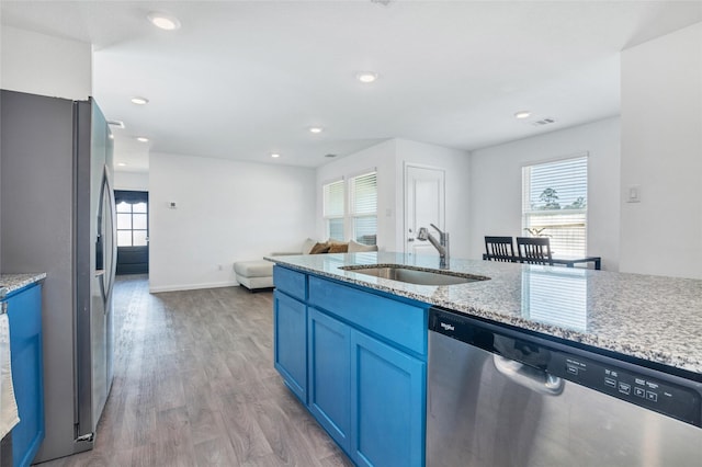 11947 Midas Ln, Willis, TX 77378 - kitchen featuring appliances with stainless steel finishes, a sink, light wood-style flooring, healthy amount of natural light, and recessed lighting