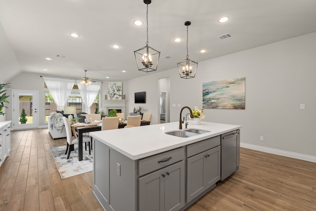 2915 Finch Ct, Katy, TX 77493 - kitchen with gray cabinets, a sink, dishwasher, wood finished floors, and light countertops