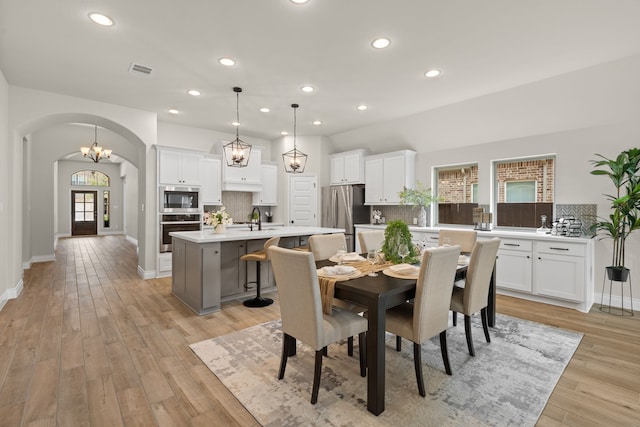 2915 Finch Ct, Katy, TX 77493 - dining space featuring arched walkways, recessed lighting, light wood finished floors, and baseboards