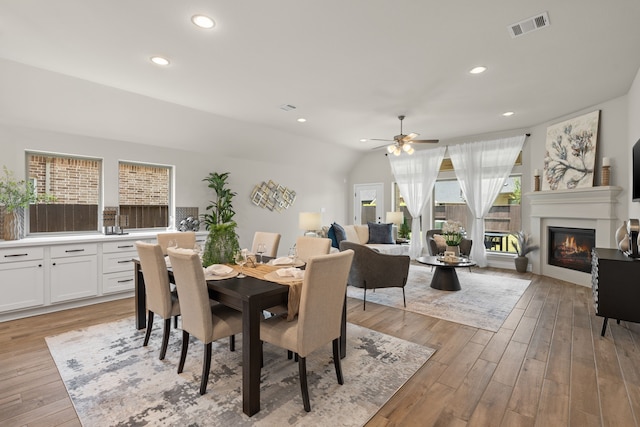 2915 Finch Ct, Katy, TX 77493 - dining area with a ceiling fan, a glass covered fireplace, light wood-style floors, lofted ceiling, and recessed lighting