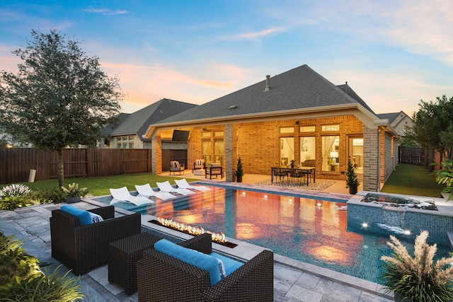 2915 Finch Ct, Katy, TX 77493 - pool at dusk featuring a patio, an outdoor living space with a fire pit, and outdoor dining space