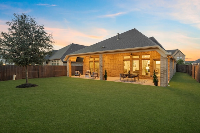 2915 Finch Ct, Katy, TX 77493 - back of house at dusk featuring brick siding, a patio area, and roof with shingles