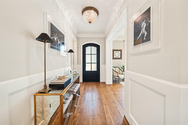 2202 Sul Ross St, Houston, TX 77098 - doorway with a wainscoted wall, ornamental molding, light wood-style floors, arched walkways, and a decorative wall