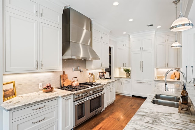 2202 Sul Ross St, Houston, TX 77098 - kitchen featuring range with two ovens, wall chimney range hood, a sink, white cabinets, and decorative backsplash