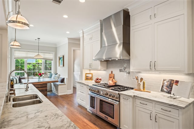 2202 Sul Ross St, Houston, TX 77098 - kitchen with range with two ovens, wall chimney range hood, a sink, dark wood-style flooring, and crown molding
