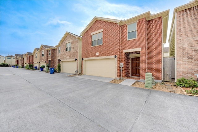 3721 Main Poplar Dr, Houston, TX 77025 - view of front of property featuring a residential view, brick siding, an attached garage, and driveway