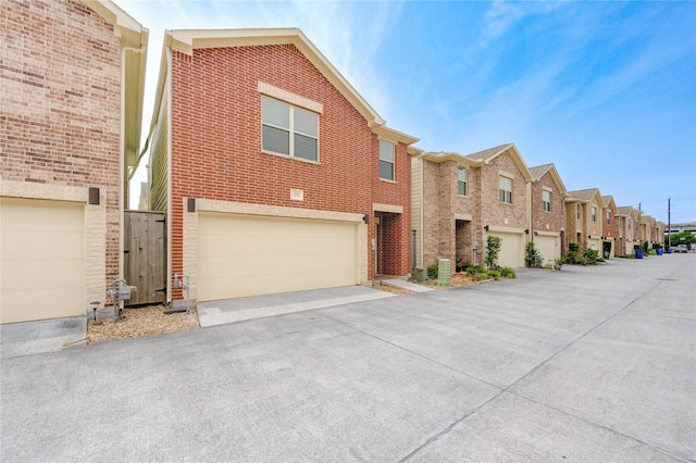 3721 Main Poplar Dr, Houston, TX 77025 - view of property featuring a residential view, a garage, brick siding, and driveway