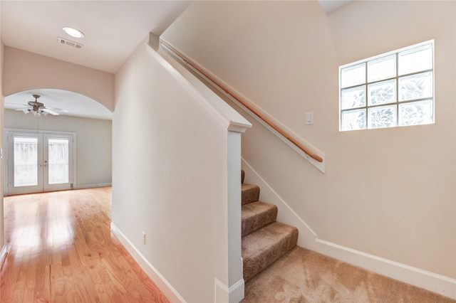 3721 Main Poplar Dr, Houston, TX 77025 - stairway with arched walkways, a ceiling fan, baseboards, french doors, and wood finished floors