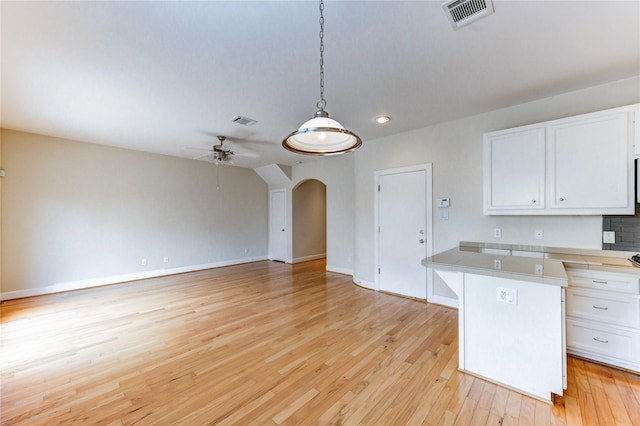 3721 Main Poplar Dr, Houston, TX 77025 - kitchen with white cabinetry, light wood-style flooring, arched walkways, ceiling fan, and recessed lighting