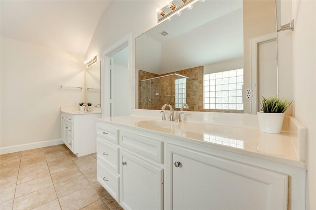 3721 Main Poplar Dr, Houston, TX 77025 - bathroom featuring lofted ceiling, two vanities, tiled shower, and tile patterned floors