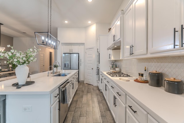 30707 Thicket Ct, Fulshear, TX 77441 - kitchen with appliances with stainless steel finishes, under cabinet range hood, white cabinets, light countertops, and a chandelier