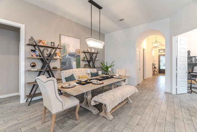 30707 Thicket Ct, Fulshear, TX 77441 - dining area featuring light wood finished floors, arched walkways, and a chandelier