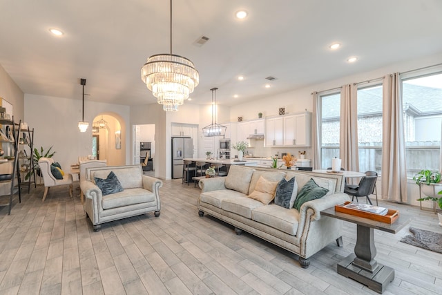 30707 Thicket Ct, Fulshear, TX 77441 - living room with a chandelier, light wood-style floors, recessed lighting, and arched walkways