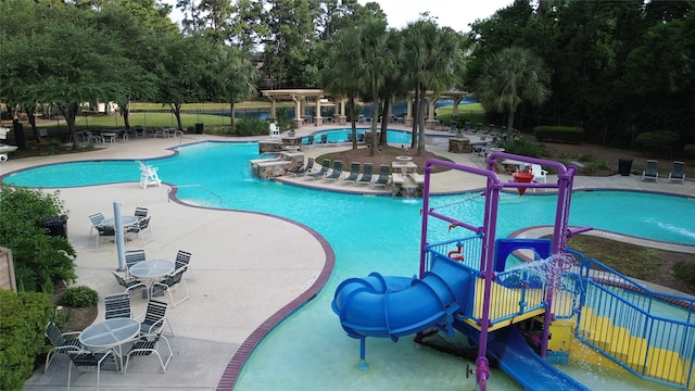 18002 Outback Lakes Trl, Humble, TX 77346 - community pool with a water slide, a water play area, a patio, and view of scattered trees