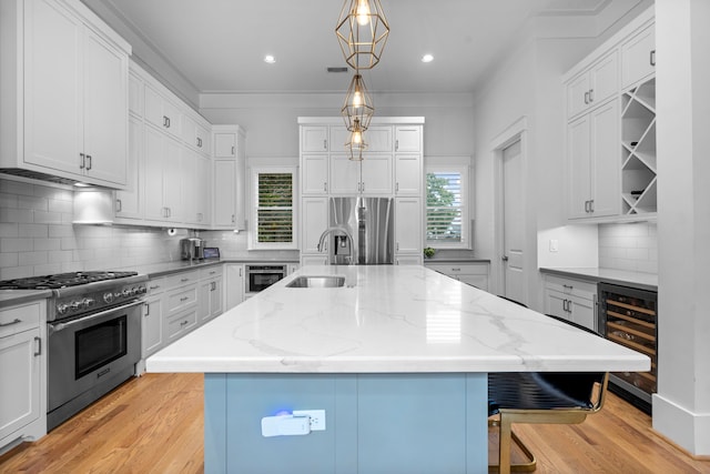 208 Aurora St Unit B, Houston, TX 77008 - kitchen with wine cooler, stainless steel appliances, a sink, a kitchen breakfast bar, and light wood finished floors