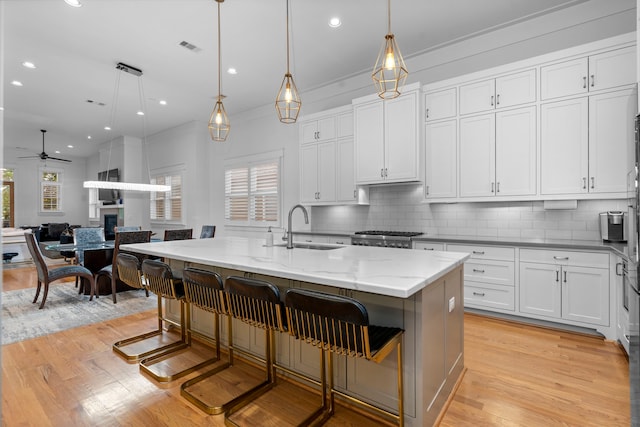 208 Aurora St Unit B, Houston, TX 77008 - kitchen with a sink, a ceiling fan, light wood-style flooring, a fireplace, and decorative backsplash