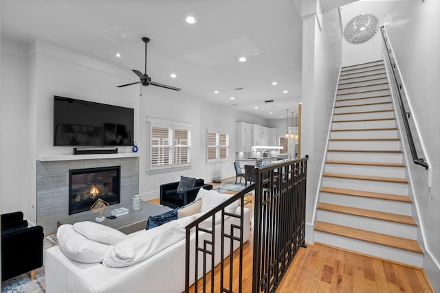 208 Aurora St Unit B, Houston, TX 77008 - living room featuring a tiled fireplace, ceiling fan, recessed lighting, light wood-type flooring, and stairs