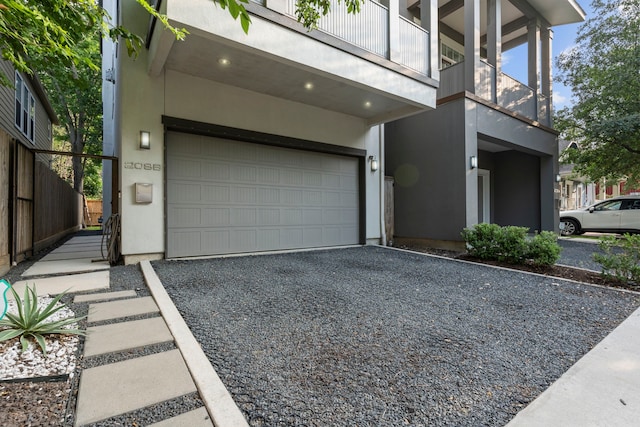 208 Aurora St Unit B, Houston, TX 77008 - view of front of house featuring a garage, gravel driveway, a balcony, and stucco siding