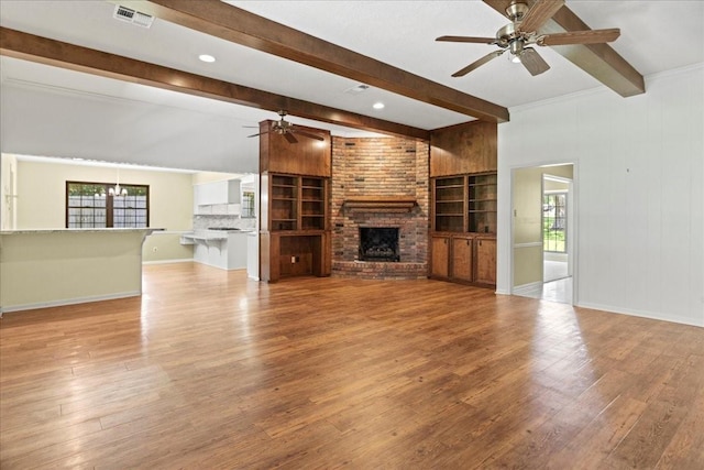 30814 Quinn Rd, Tomball, TX 77375 - unfurnished living room featuring ceiling fan, beam ceiling, healthy amount of natural light, and wood finished floors