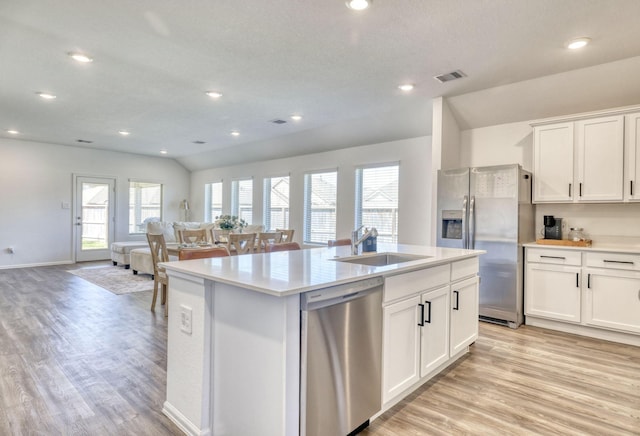 1386 Antigua Dr, Conroe, TX 77301 - kitchen with appliances with stainless steel finishes, a sink, light wood finished floors, a kitchen island with sink, and recessed lighting
