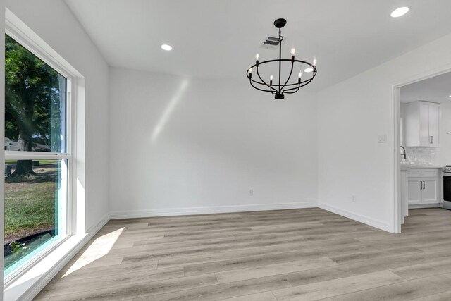 9602 Ballin David Dr, Spring, TX 77379 - unfurnished dining area with a chandelier, light wood-style floors, recessed lighting, baseboards, and a sink