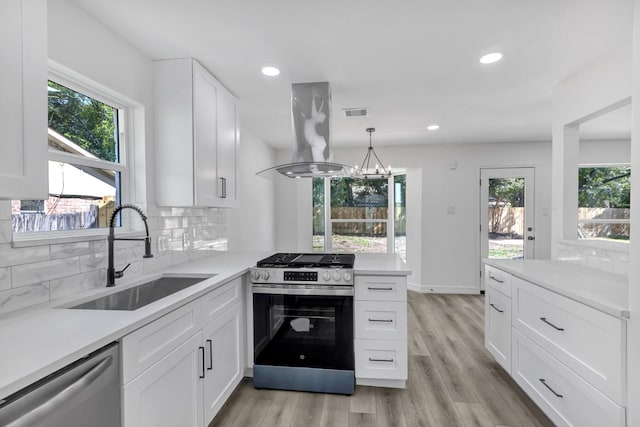 9602 Ballin David Dr, Spring, TX 77379 - kitchen with stainless steel appliances, island range hood, a sink, healthy amount of natural light, and recessed lighting