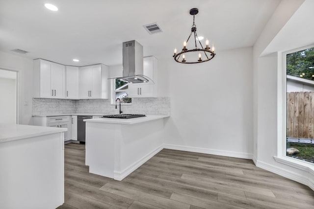 9602 Ballin David Dr, Spring, TX 77379 - kitchen featuring exhaust hood, stainless steel dishwasher, a chandelier, white cabinetry, and decorative backsplash