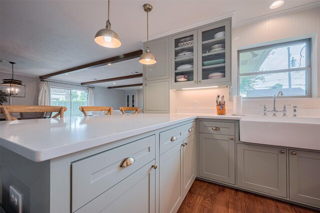 2211 Wycliffe Dr, Houston, TX 77043 - kitchen featuring gray cabinetry, a sink, a peninsula, decorative light fixtures, and glass insert cabinets