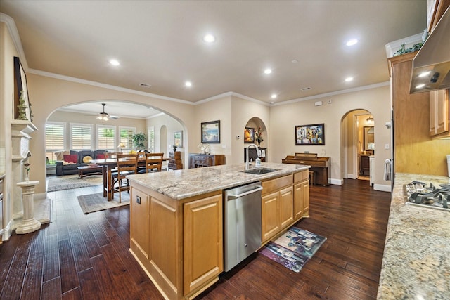 5131 Anthony Springs Ln, Sugar Land, TX 77479 - kitchen featuring stainless steel appliances, arched walkways, dark wood-style floors, an island with sink, and wall chimney exhaust hood