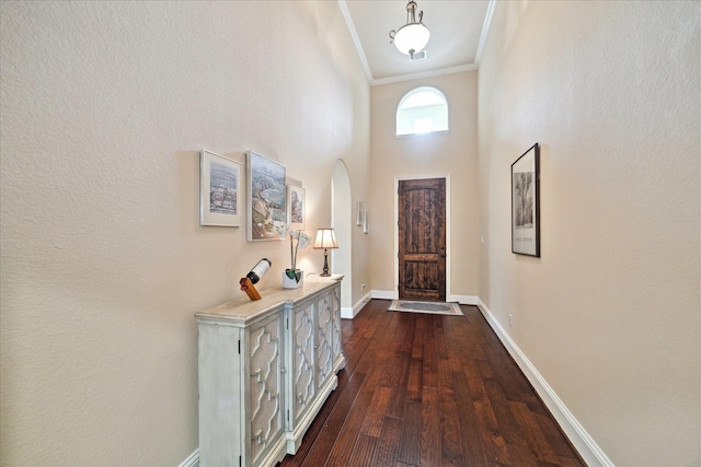 5131 Anthony Springs Ln, Sugar Land, TX 77479 - foyer entrance featuring crown molding, arched walkways, dark wood-style floors, baseboards, and a towering ceiling