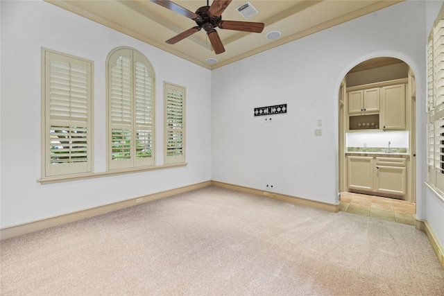 16610 Champagne Falls Ct, Spring, TX 77379 - spare room with light colored carpet, ceiling fan, a sink, arched walkways, and baseboards