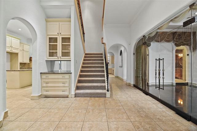 16610 Champagne Falls Ct, Spring, TX 77379 - stairway featuring tile patterned flooring, ornamental molding, arched walkways, and baseboards