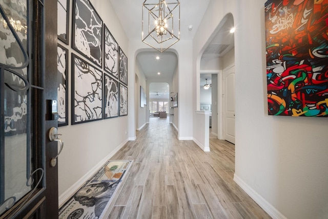 24103 Corinaldo Ct, Katy, TX 77493 - entryway with arched walkways, light wood finished floors, baseboards, and a chandelier
