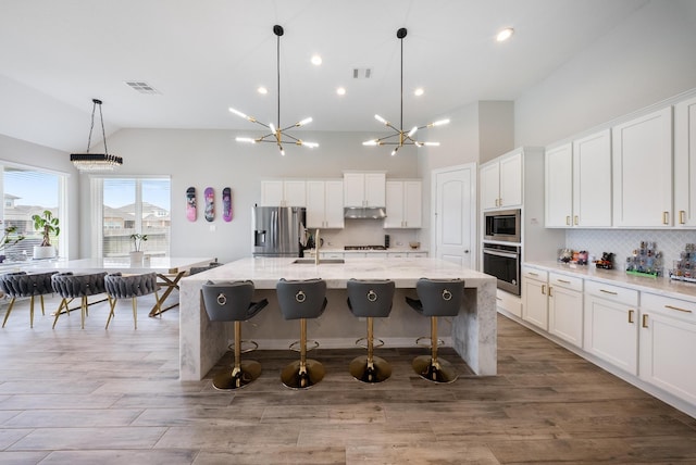 24103 Corinaldo Ct, Katy, TX 77493 - kitchen featuring stainless steel appliances, a sink, backsplash, a large island, and white cabinets