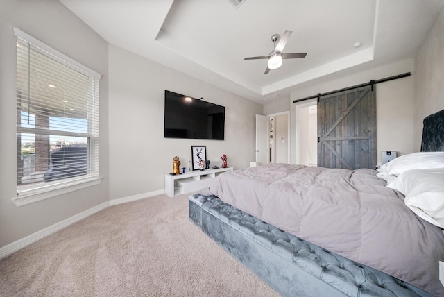 24103 Corinaldo Ct, Katy, TX 77493 - carpeted bedroom featuring a barn door, a raised ceiling, baseboards, and ceiling fan