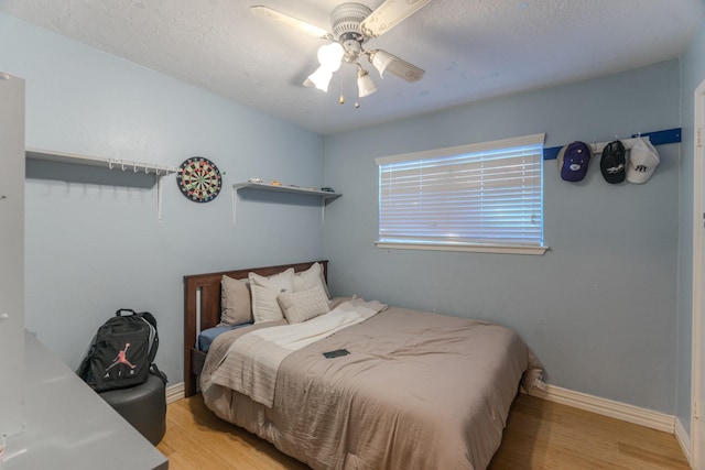 14811 S Bristol Harbour Cir, Houston, TX 77084 - bedroom featuring wood finished floors, a ceiling fan, baseboards, and a textured ceiling
