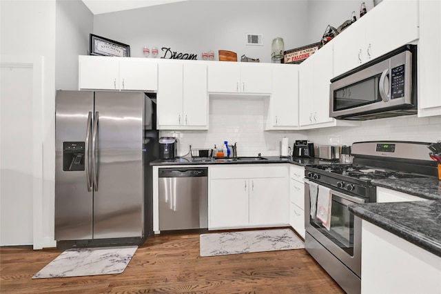 914 W 25th St Unit 2, Houston, TX 77008 - kitchen with stainless steel appliances, a sink, wood finished floors, and decorative backsplash
