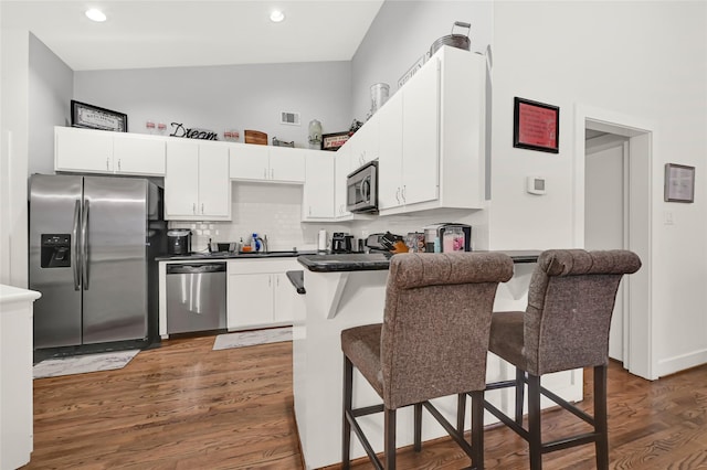914 W 25th St Unit 2, Houston, TX 77008 - kitchen with appliances with stainless steel finishes, a breakfast bar area, white cabinets, a peninsula, and backsplash