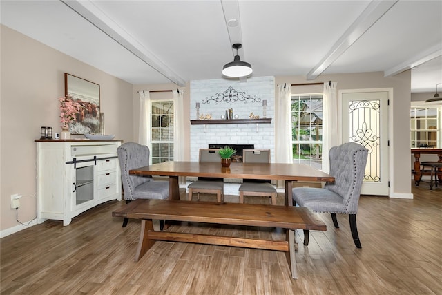 676 Ravensworth Dr, Conroe, TX 77302 - dining space featuring beam ceiling, a fireplace, baseboards, and wood finished floors