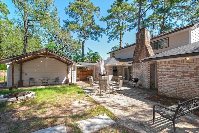 676 Ravensworth Dr, Conroe, TX 77302 - rear view of property featuring a chimney, a patio area, and brick siding
