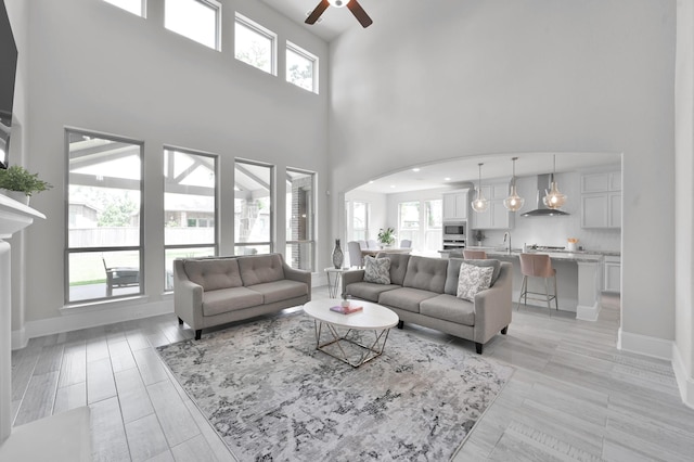 503 Woodsy Pine Ct, Conroe, TX 77304 - living room featuring arched walkways, ceiling fan, a high ceiling, and baseboards