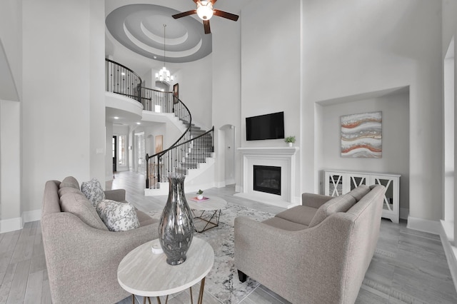 503 Woodsy Pine Ct, Conroe, TX 77304 - living room with a towering ceiling, a ceiling fan, baseboards, a glass covered fireplace, and stairway