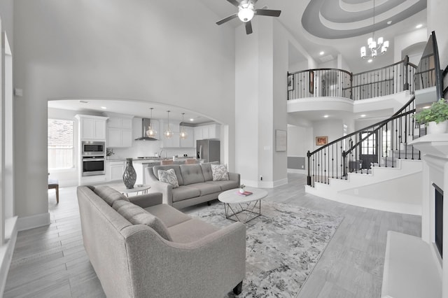 503 Woodsy Pine Ct, Conroe, TX 77304 - living room with a towering ceiling, baseboards, a chandelier, arched walkways, and a ceiling fan