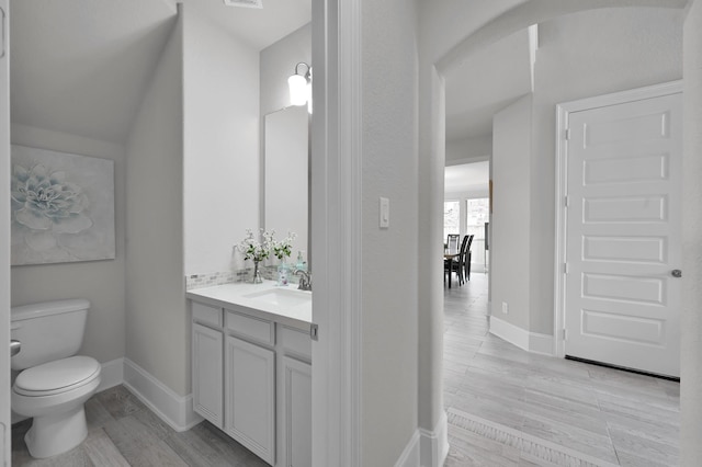 503 Woodsy Pine Ct, Conroe, TX 77304 - bathroom with vanity, toilet, baseboards, and wood finished floors