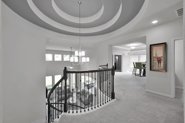 503 Woodsy Pine Ct, Conroe, TX 77304 - hall with an upstairs landing, a chandelier, a raised ceiling, baseboards, and carpet floors
