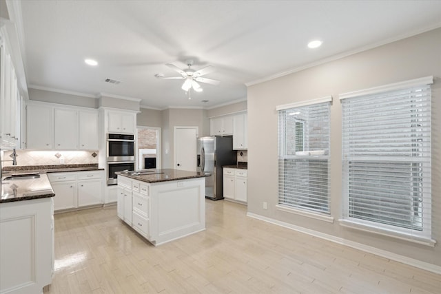 1438 Trace Dr, Houston, TX 77077 - kitchen featuring appliances with stainless steel finishes, ceiling fan, decorative backsplash, white cabinets, and crown molding