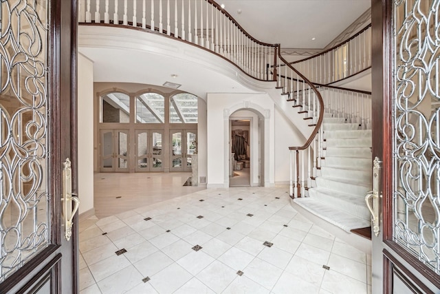 903 Old Lake Rd, Houston, TX 77057 - foyer entrance with arched walkways, a high ceiling, stairs, baseboards, and tile patterned floors