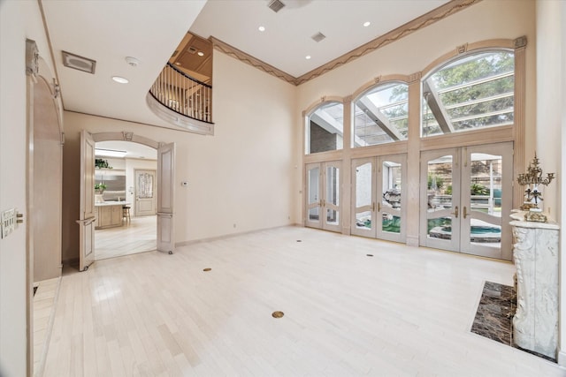 903 Old Lake Rd, Houston, TX 77057 - unfurnished living room with french doors, a high ceiling, arched walkways, wood finished floors, and recessed lighting