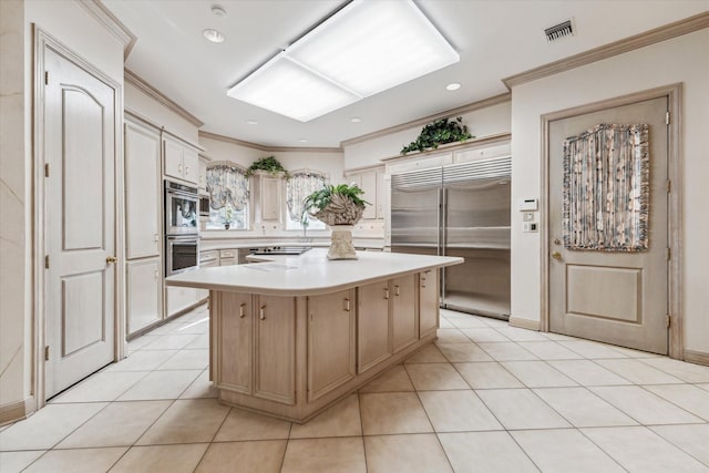 903 Old Lake Rd, Houston, TX 77057 - kitchen featuring stainless steel appliances, ornamental molding, light countertops, a center island, and light tile patterned floors